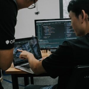 two men working on computers in an office