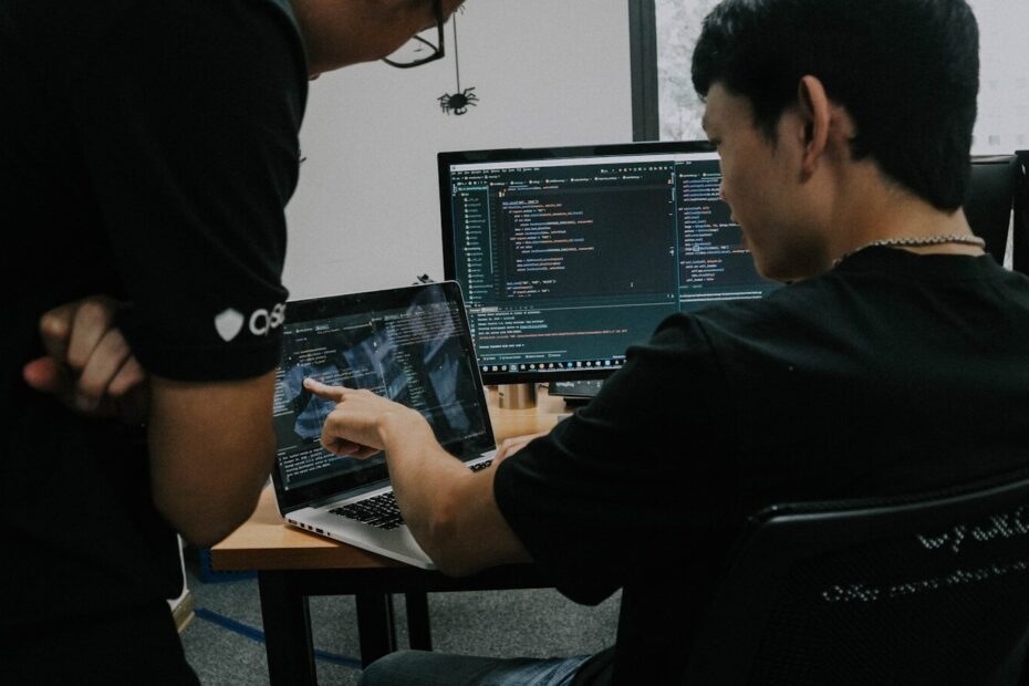 two men working on computers in an office